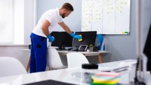 Persona limpiando una oficina moderna para mantener un entorno laboral saludable y libre de gérmenes