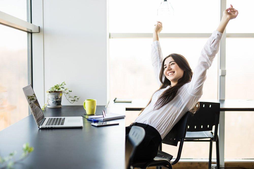 Mujer relajada y feliz en oficina bien iluminada
