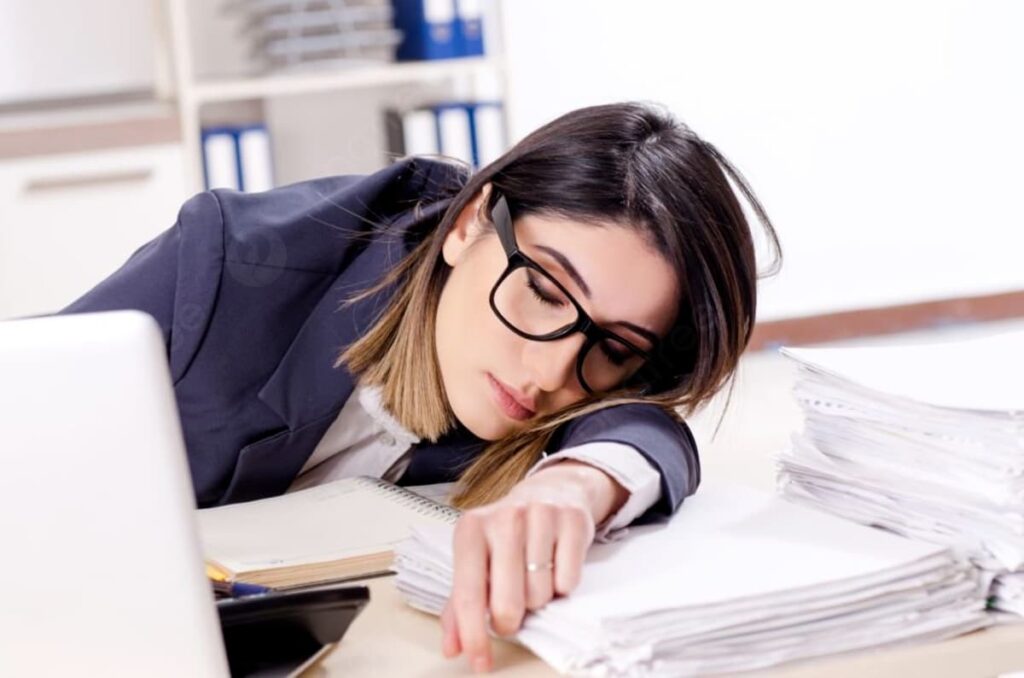 Mujer dormida sobre su escritorio en la oficina