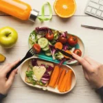Comida saludable en táper para oficina con frutas, verduras y zumo natural