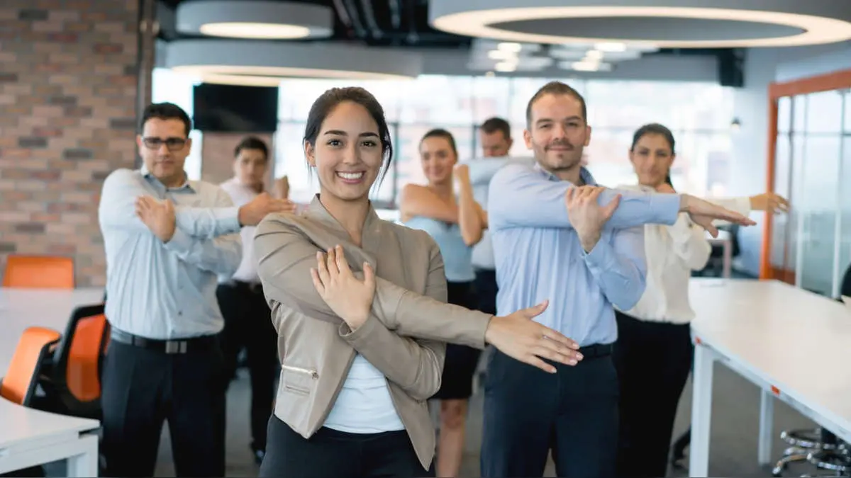 Grupo de empleados estirando en la oficina